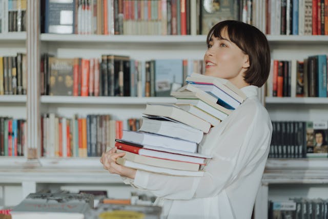 Università per persone con disabilità: una studentessa porta una grossa pila di libri