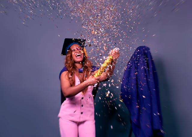 Università e accessibilità: una donna con un tailleur rosa festeggia la sua laurea