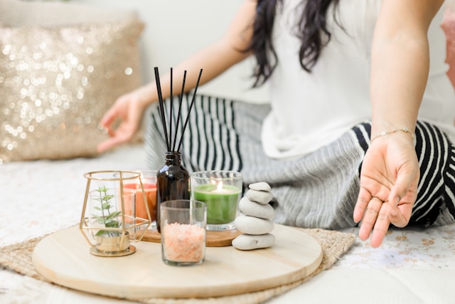 accettare una malattia cronica attraverso la mindfulness: una donna medita a piedi incrociati con bastoncini di incenso